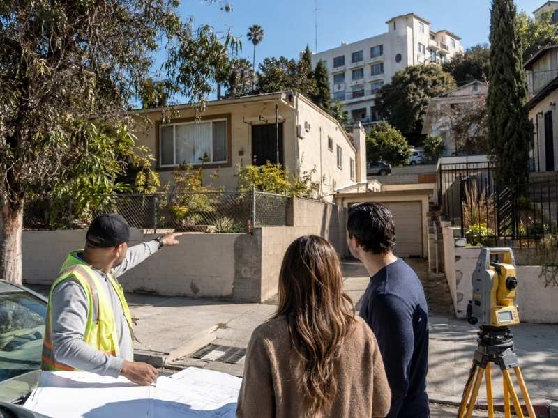 Closing Survey Property Review Los Angeles CA | Los Angeles Land Surveying Closing survey in Los Angeles CA showing buyers and a surveyor reviewing property lines, improvements, and unexpected site conditions before closing.